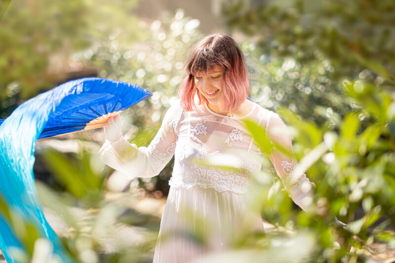 young adult dances with long scarf in nature