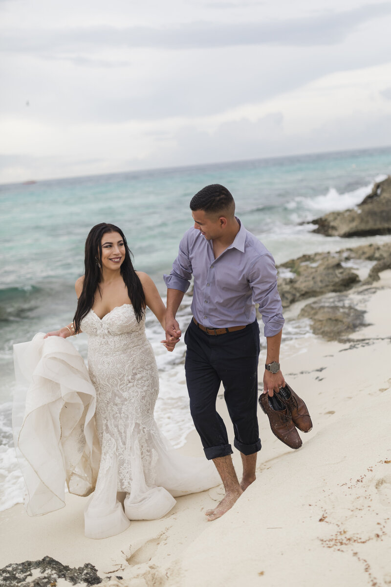 bride and groom walking on beach at cancun wedding
