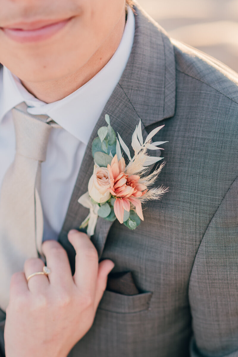 photo of groom wearing a grey suit and boutonniere taken by luxury wedding photographer La Jolla