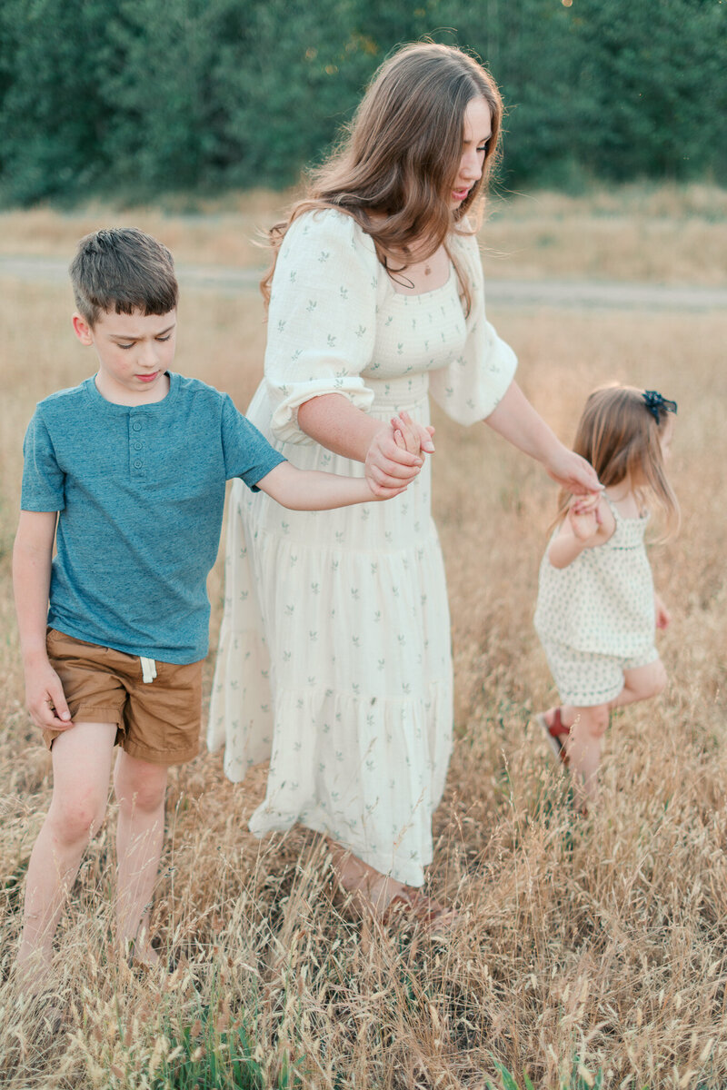 A mother and two kids in a field in Portland during Golden hour