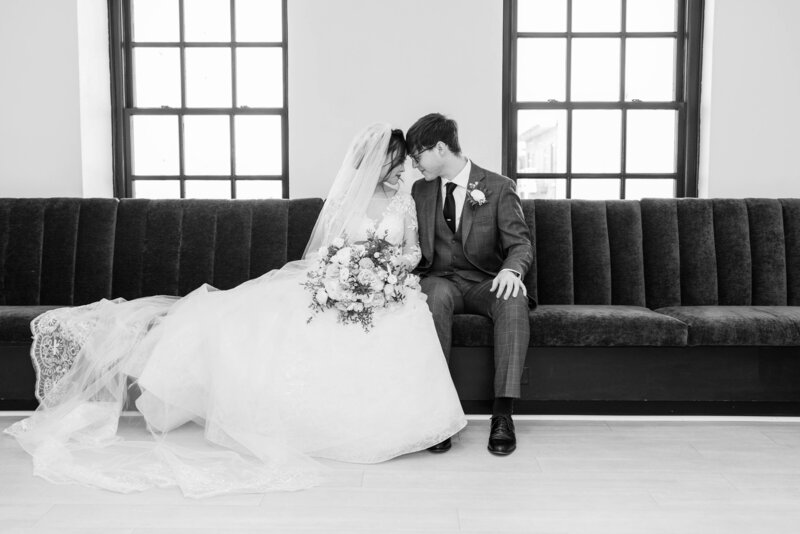 Bride and Groom sitting while nuzzling on couch at 10 South in Madison, Wisconsin. 