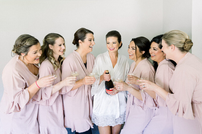 bride and bridesmaids popping champagne