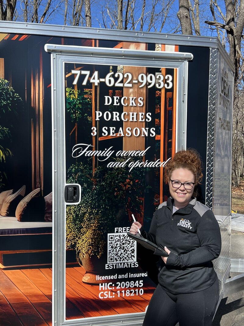 Deck Contractor Kerry stands with her wrapped trailer