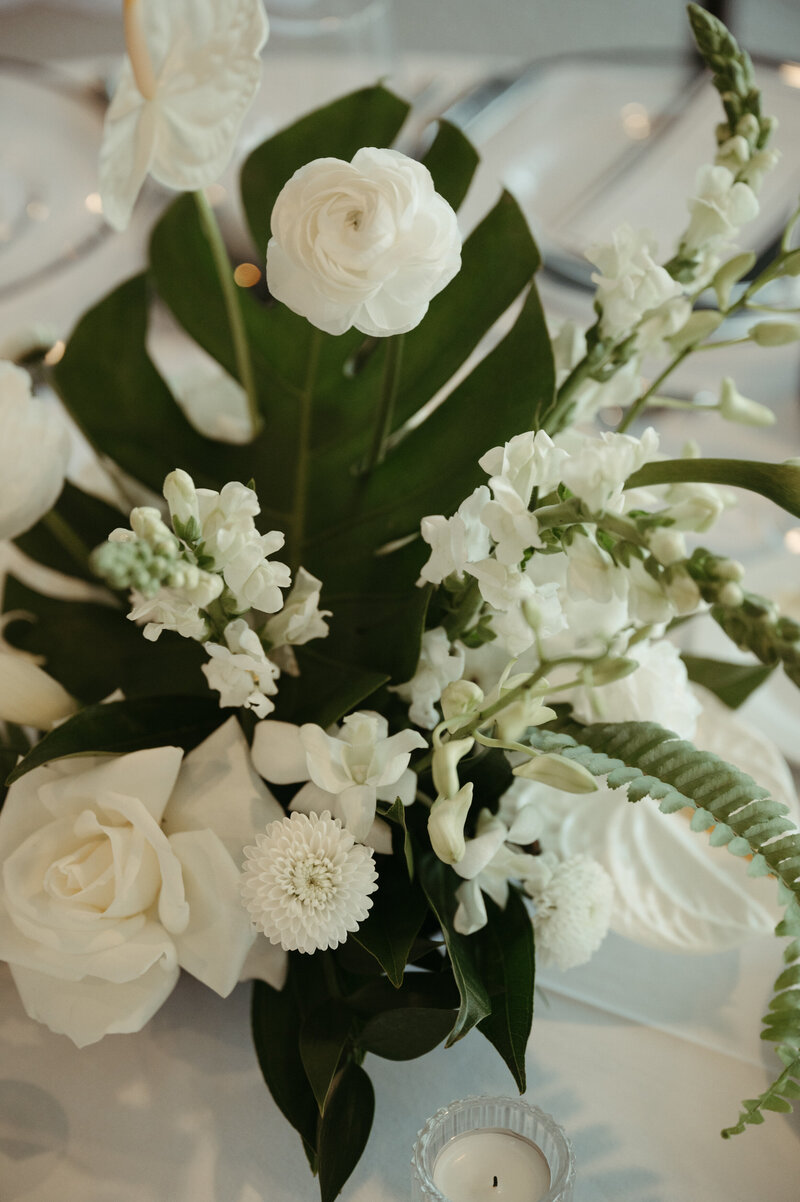 White floral arrangement with tropical greenery and modern blooms, styled by The Eventful Gals for an elevated wedding reception.