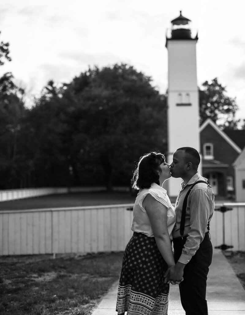 Couple kissing in front of lighthouse on Presque Isle State Park