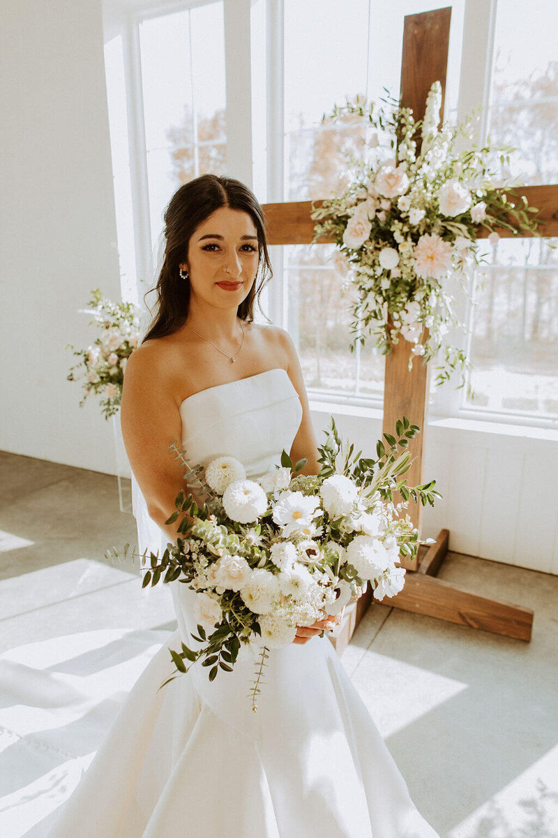 woman in wedding dress posing with flowers