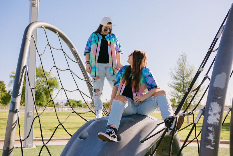 Two people sitting on a playground.