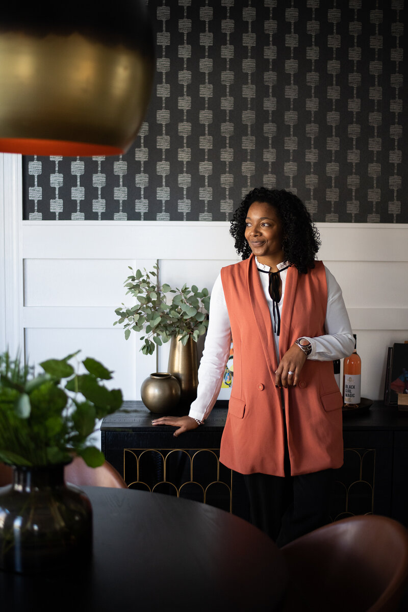 Marie standing in a dining room that she designed