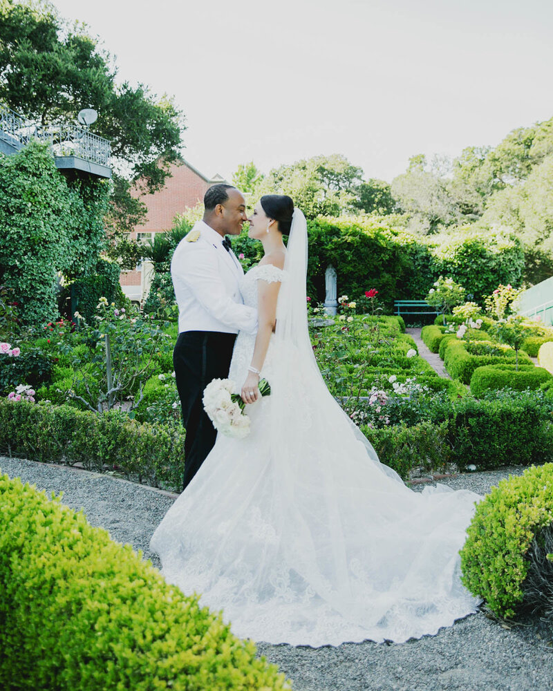Bride + Groom face each other as the Bride holds the bouquet