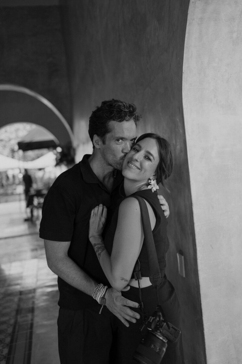 Cabo photographers looking at the camera — Fred kisses Mel on the cheek