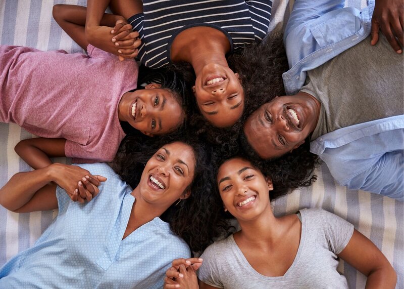 Black family with teenage girls smiling