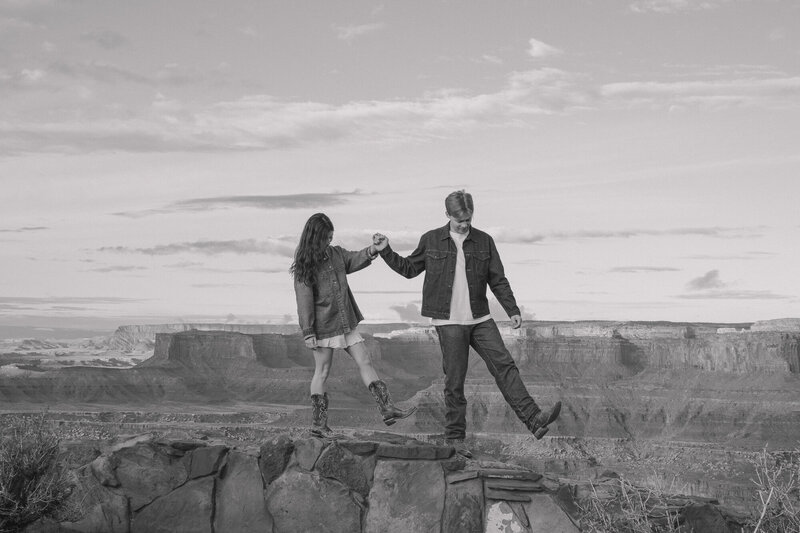 Couple walking along the edges of the red rocks in Moab