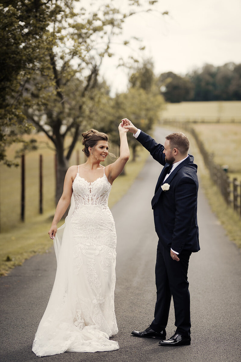 A bride and groom dancing outdoors on their wedding day.