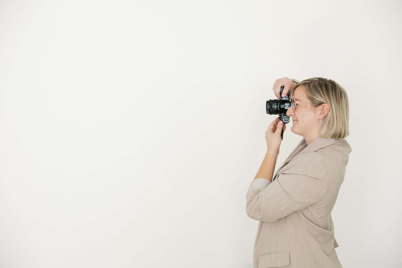Woman with short blonde hair taking photo