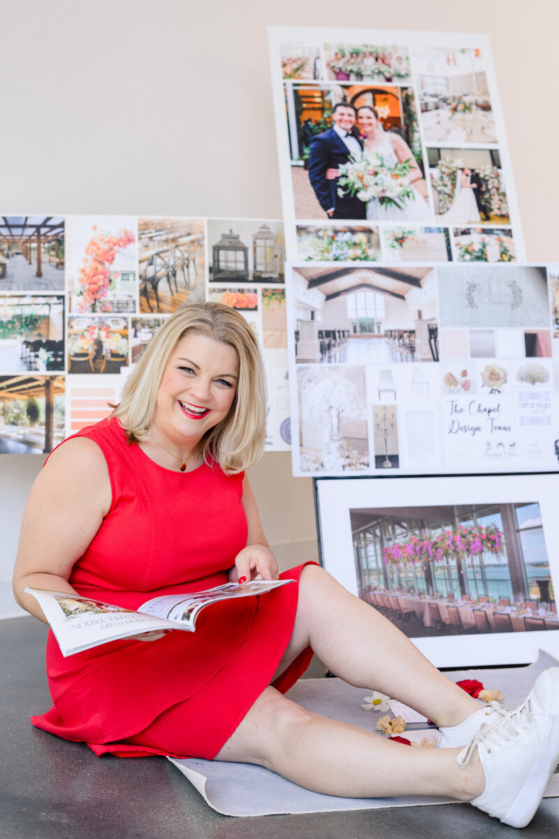 Wedding planner in a red dress reviewing inspiration boards, reflecting creative, detail-oriented Austin wedding planning services.