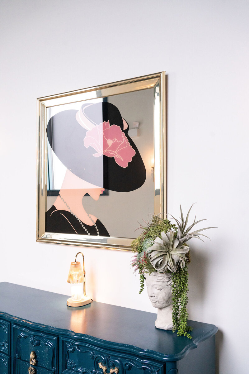 antique art piece paired with evergreen bust and ambient lighting in venue entryway