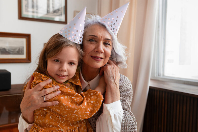Grand-mère et sa petite fille enlacée réunies pour une fête d'anniversaire organisée par une event planner.
