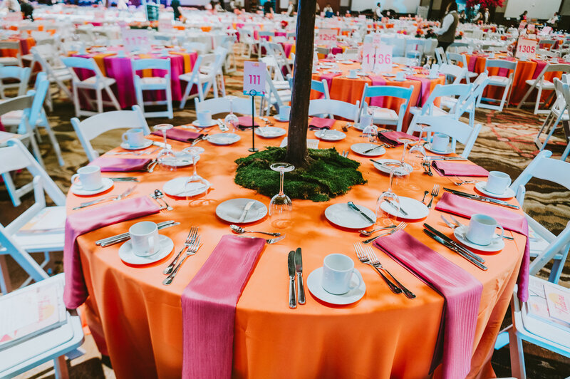 Vibrant table setting with orange linens and pink napkins at a professionally designed corporate gala in Phoenix, Arizona—photographed by MISGIF’s corporate event photography team to highlight décor, branding, and ambiance.