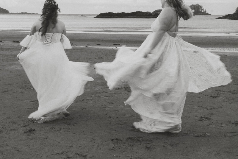 Brides spinning in wedding dresses during wedding portraits at Mackenzie beach in Tofino by Latitude 49 Photography.