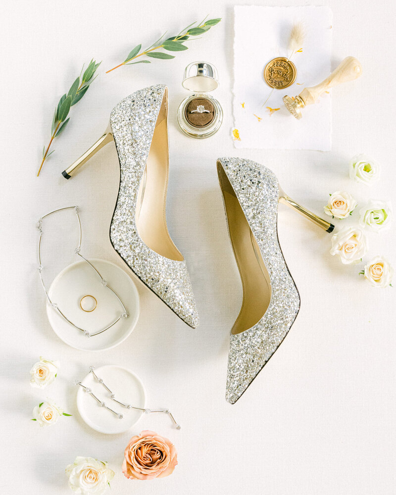 This elegant layflat photograph showcases the bride's high-end luxury getting ready items, beautifully arranged on her wedding day. Each detail, from jewelry to shoes, reflects sophistication and style, capturing the essence of her luxury celebration.