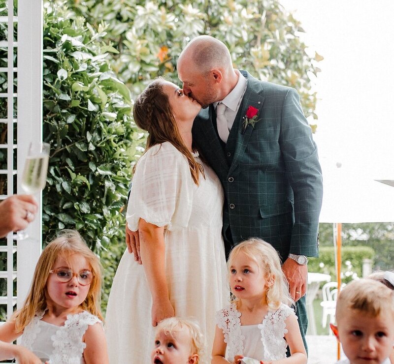 Bride and groom first kiss New Zealand backyard wedding