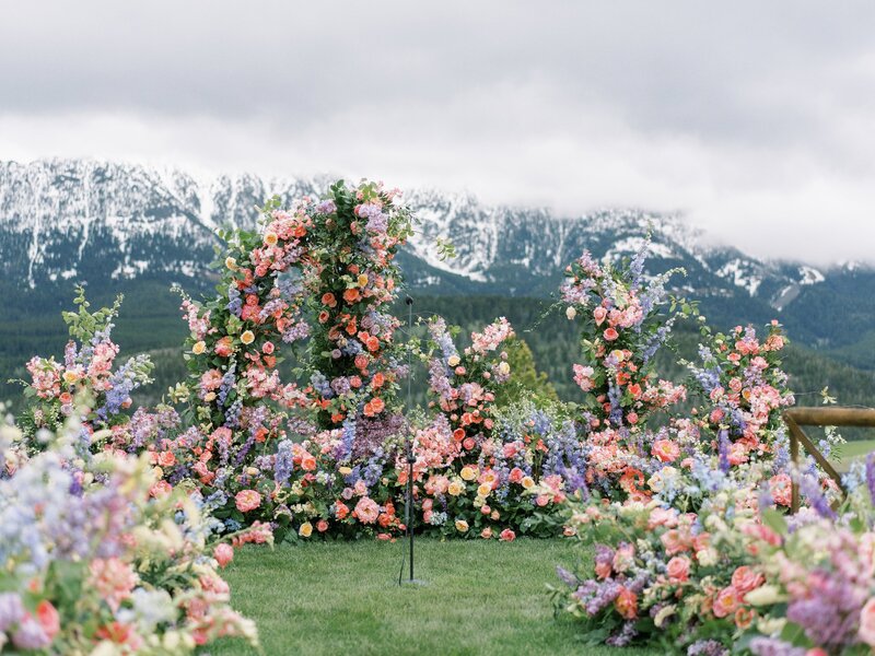 Large, elaborate floral arrangements outside in front of a mountain landscape