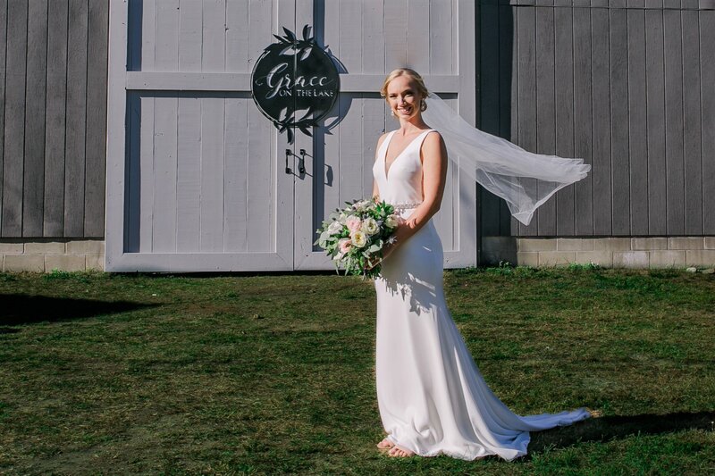Bride standing with Grace on the Lake sign on door behind her | Klein Wedding in Harmony, Maine taken by Wedding Photographer