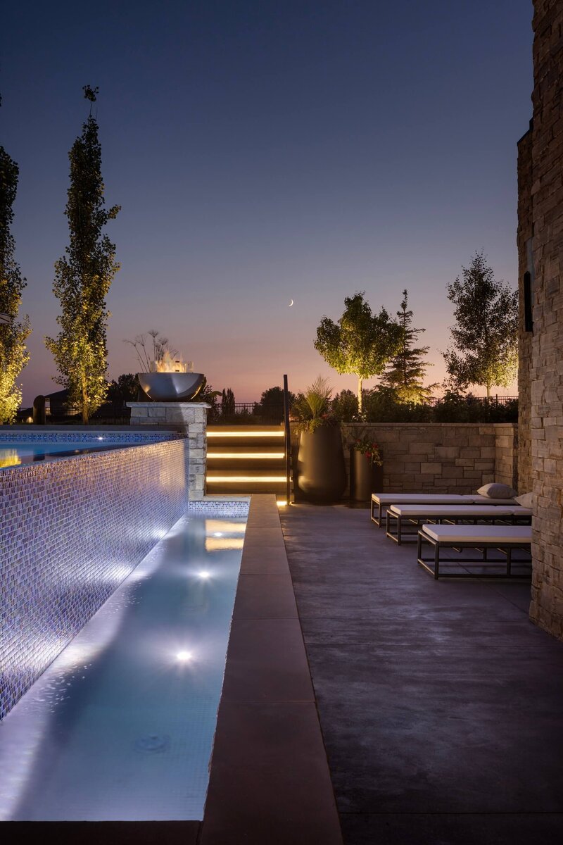 A large outdoor home infinity pool with poolside loungers. 