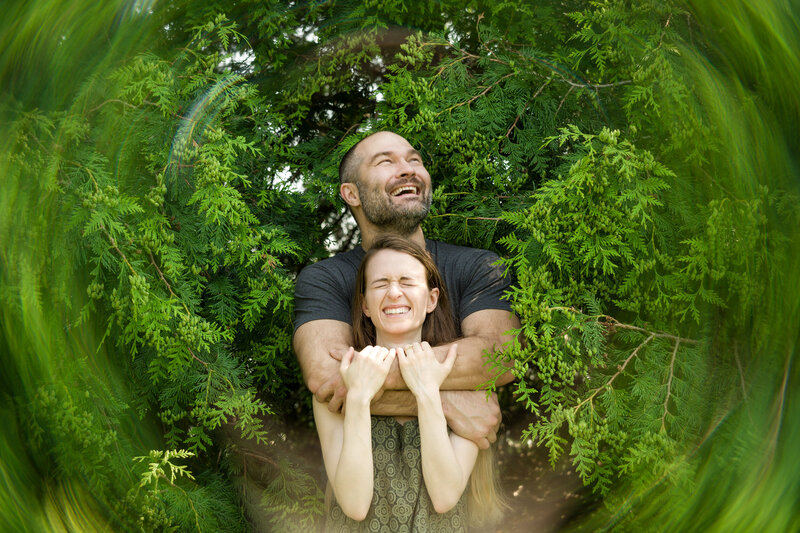 Couple bursting into laughter with a creative camera effect during their one-of-a-kind engagement session, full of personality.