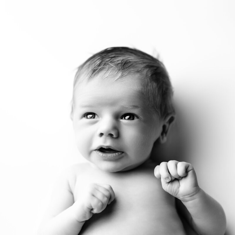 A joyful newborn portrait highlighting bright eyes and a tender expression, perfect for showcasing baby’s emerging personality.