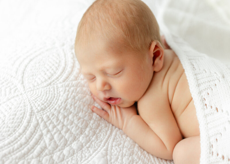 newborn baby boy sleeping on a white heirloom blanket with Constance calton photography