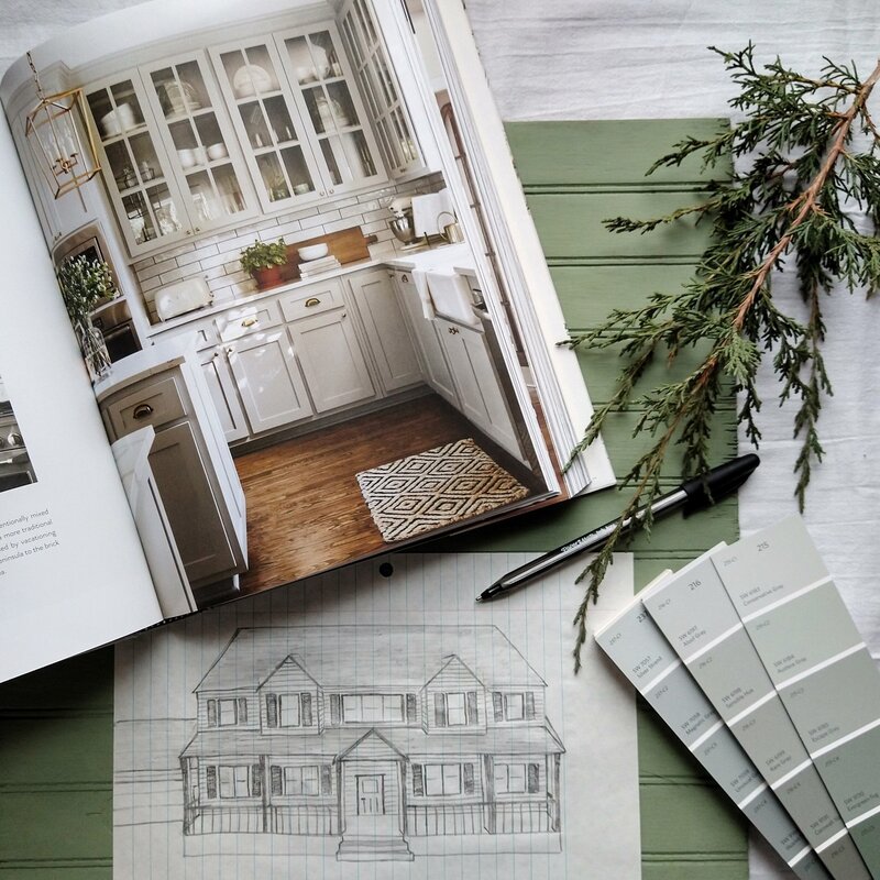 A design book, paint samples, and a house sketch.