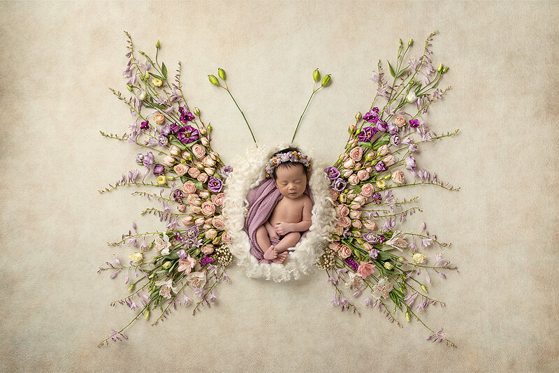 Newborn girl in floral butterfly, a Dallas newborn photographer.