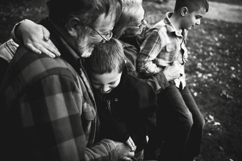 GRANDSON WITH ARMS WRAPPED AROUND GRANDPA - OUTDOOR FALL FAMILY PHOTOGRAPHY - DOCUMENTARY FAMILY PHOTOGRAPHY - TREMPEALEAU WISCONSIN