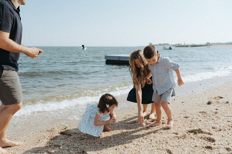 family playing in the sand during family photos at the beach captured by NYC family photographer Elsie Goodman 
