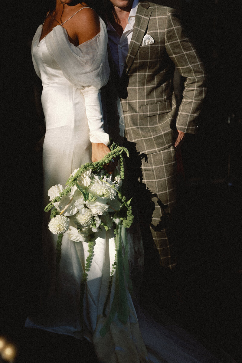 A beautifully styled wedding invitation suite for Dana & Jake, featuring modern typography, warm tones, and delicate wedding rings placed on top