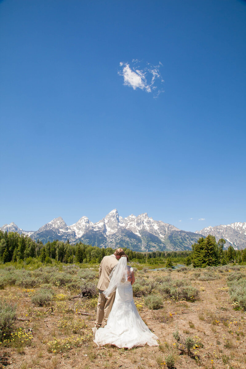 Couple enjoying a moment on the green at Jackson Hole Golf and Tennis, with Grand Teton National Park in the background.