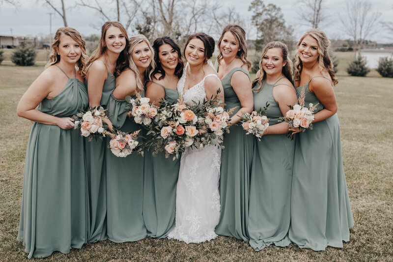 Bride with bridesmaids dressed in sage green dresses at dutch ford farm wedding