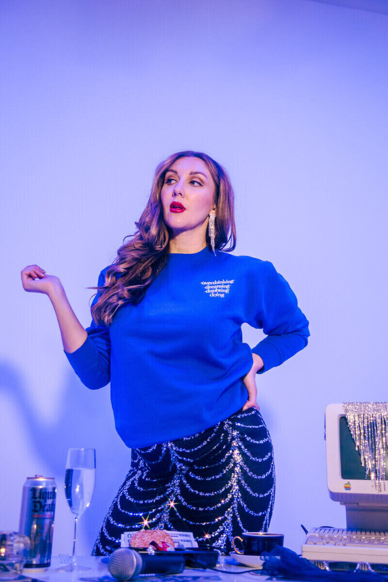 Sasha posing wearing bright blue jumper