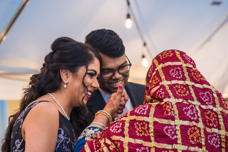 East Indian couple with Grooms mom performing a ritual at the reception