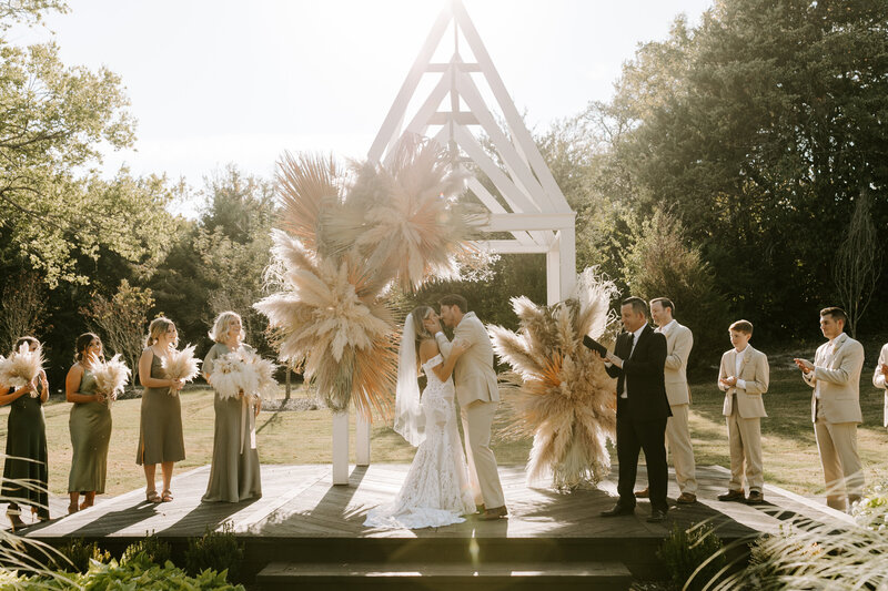 wedding party posing under arch