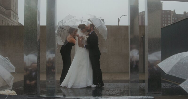 bride and groom kissing at ceremony alter in rain