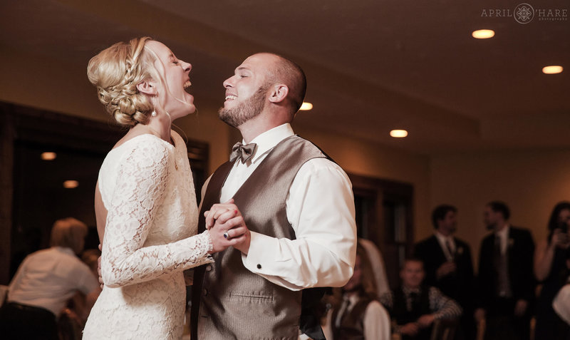 Couple laughs together during first dance inside the Mountain View Conference Room wedding reception at the Lodge at Breckenridge in Colorado