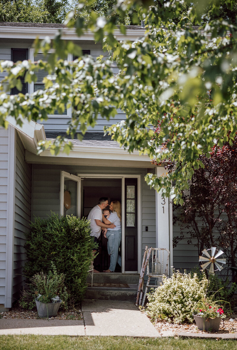 A front porch portrait of a mother, father and newborn son in St. Louis, Missouri.
