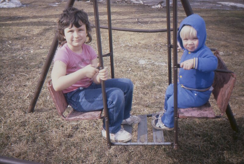 a little girl on a homemade swing set in the 1980's.