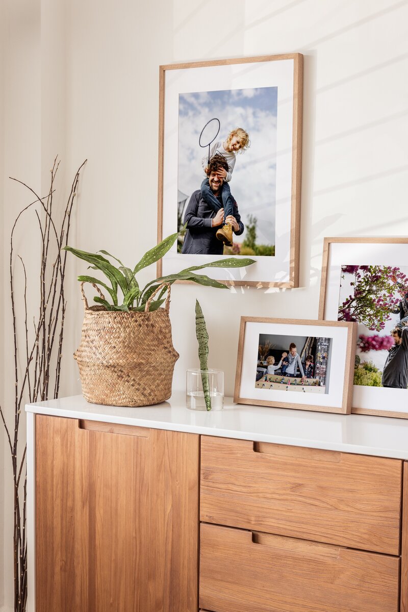 a wall with three framed family pictures