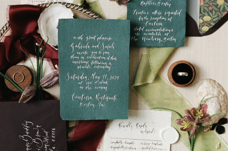 Film photo of a wedding invitation suite flatlay featuring green and burgundy tones, velvet ribbon, and handwritten calligraphy — designed for a wedding at Contessa Ristorante in Boston, documented by a film wedding photographer.