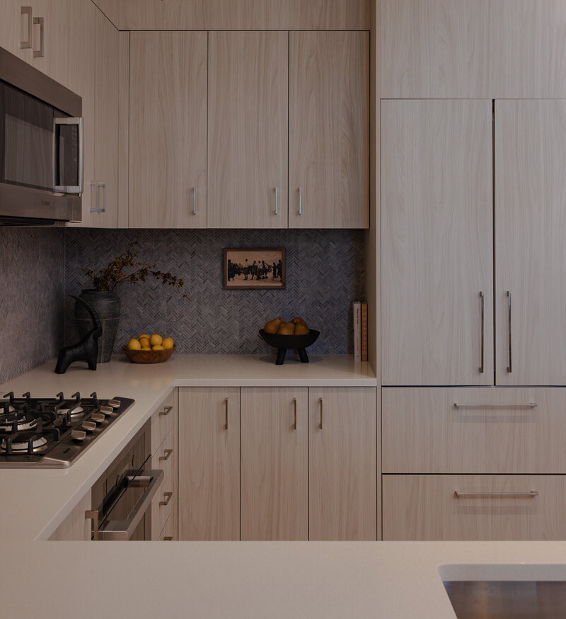 Wide view of a modern white oak kitchen with dark backsplash, styled decor, and warm tones in a Park City luxury Airbnb, designed by Sister Studio.