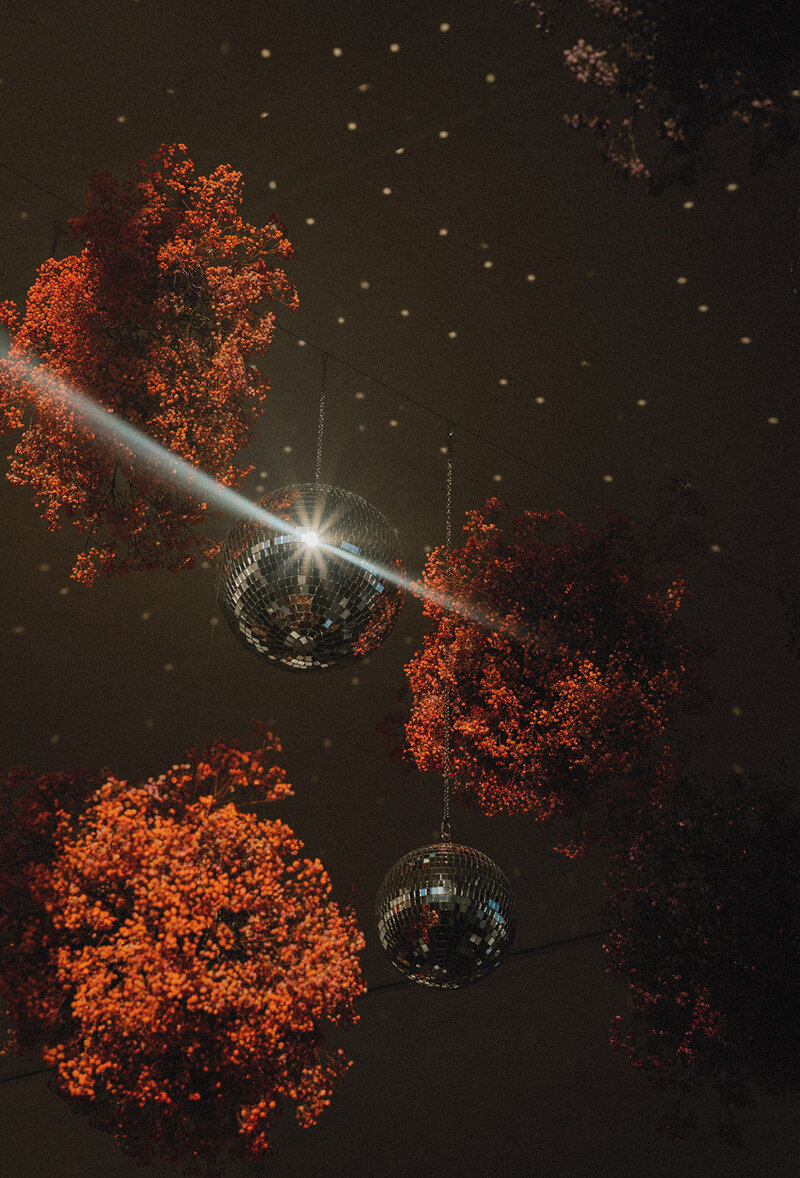 Disco balls and floral installations light up the dance floor at a Pennsylvania wedding