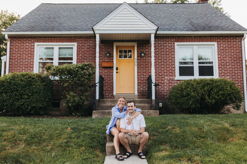 Couple sits in front of house in Philly Suburbs